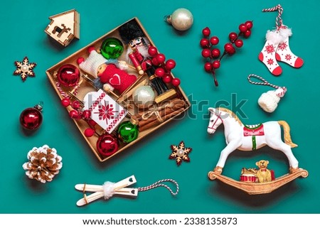 Handmade christmas care package, seasonal gift box with toys, xmas decor on green table Personalized eco friendly basket for family, friends, girl for 24 December, Christmas, New Year day Flat lay Royalty-Free Stock Photo #2338135873