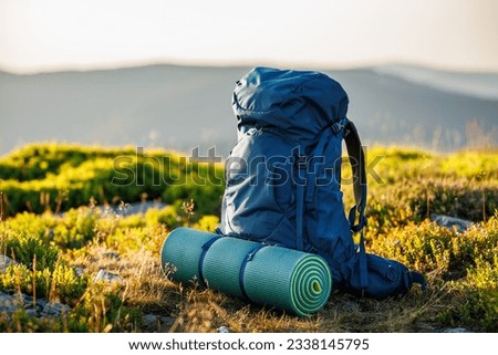 Hiking backpack with mat during trek in mountains. Camping and trekking equipment Royalty-Free Stock Photo #2338145795