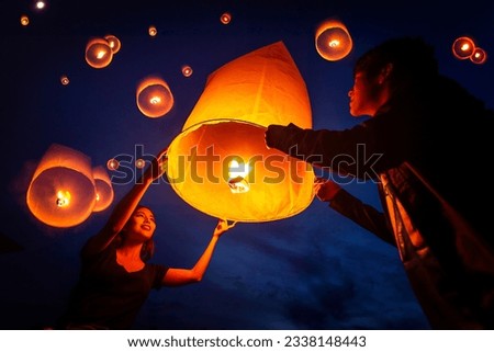 Asian couple traveller setting yi peng  lantern in loi krathong festivities celebration in chiang mai, Thailand Royalty-Free Stock Photo #2338148443
