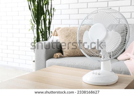 Modern electric fan on table in living room Royalty-Free Stock Photo #2338168627