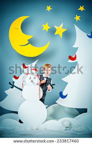 Cheerful boy in a cartoon fairy snowy forest. The magic of Christmas night. Full length portrait.