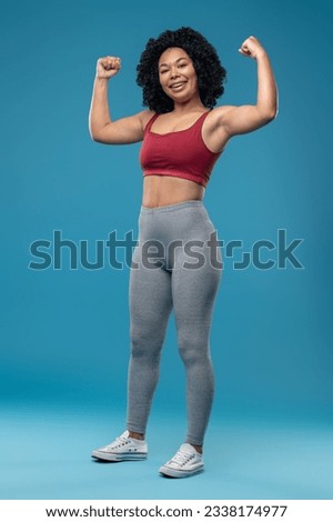 Sporty young woman in sportwear on blue background