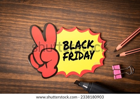Black Friday. Sticky note with text on a wooden texture background.