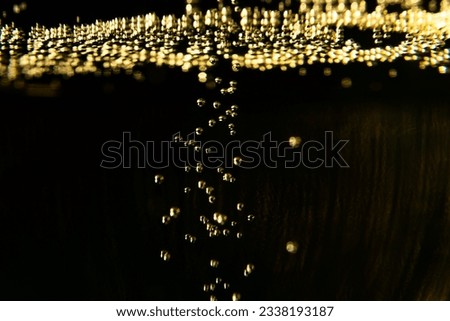 Glass of french sparkling champagne wine with bubbles on dark background, golden bubbles close up Royalty-Free Stock Photo #2338193187