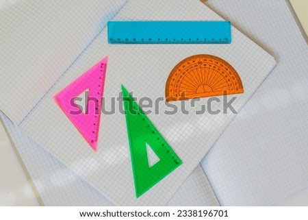 Set of colored instruments for geometry on background of open  notebooks, top view