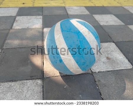 blue and white plastic ball on paving block