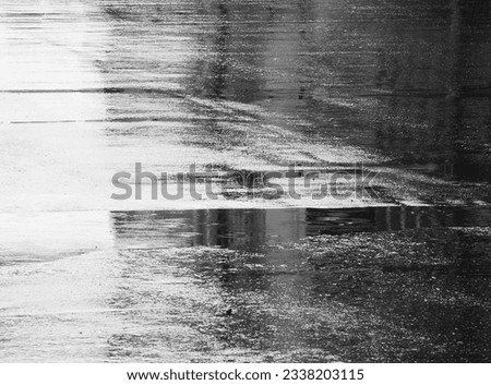 raindrops falling on wet asphalt road texture, black and white style Royalty-Free Stock Photo #2338203115
