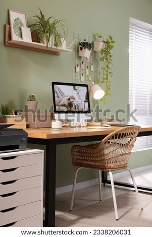 Stylish workplace with computer, laptop and lamp near olive wall at home Royalty-Free Stock Photo #2338206031