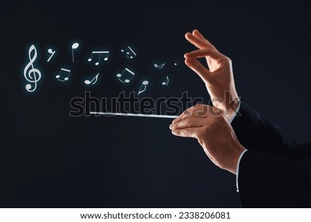 Conductor with baton and music notes on dark background, closeup Royalty-Free Stock Photo #2338206081