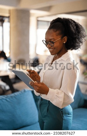 Beautiful African businesswoman using digital tablet in office. Young woman having video call. 