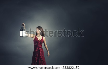 Young attractive woman in red dress with lantern