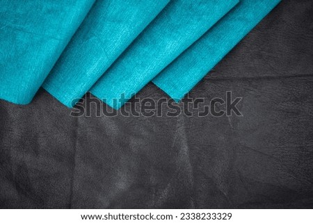 turquoise cotton fabric with pleats on black leather background, fabric template with copy space