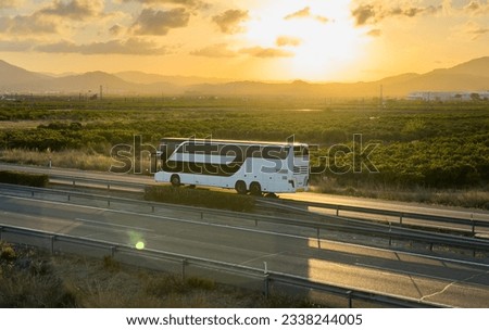 Bus on highway on sunset. Tour Bus driving on highway road. Public transport for traveling. Bus travel in Europe. Passenger bus on motorway. Transportation of passengers by public transport by road Royalty-Free Stock Photo #2338244005