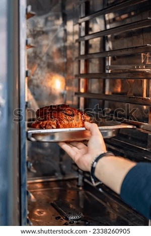 chef prepared pork knuckle meat in a oven on kitchen of restaurant