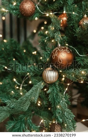 Bronze balls on the Christmas tree close-up. Christmas tree design decorations. The concept of celebrating New Year and Christmas