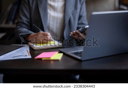 Close-up shot of asian businesswoman using phone to find new ideas to prepare business plan.