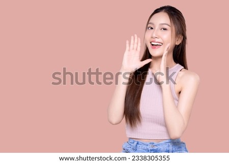 Beautiful young Asian woman with open mouths raising hands screaming announcement on isolated pink background. Facial and skin care concept for commercial advertising.