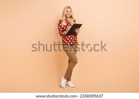 Full body photo of young model businesswoman holding textbook write caption tablet assistant checklist isolated on beige color background