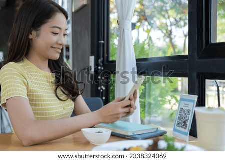 Woman use smartphone to scan QR code to pay in cafe restaurant with a digital payment without cash. Choose menu and order accumulate discount. E wallet, technology, pay online, credit card, bank app.
