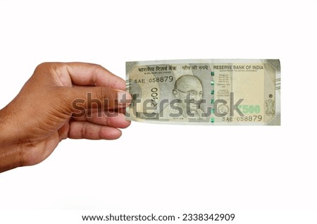 Hand Hold 500 rupees note closeup, white background. Royalty-Free Stock Photo #2338342909