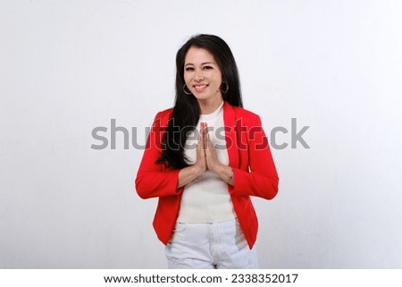 Happy Asian female with red and white dress showing namaste or welcome hand gesture isolated on white background