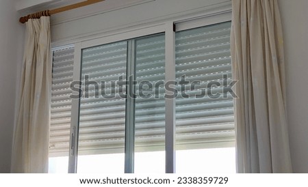 window with curtains and blind going down Royalty-Free Stock Photo #2338359729