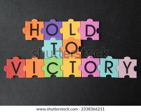 Hold to victory lined with colored puzzle letters on a black background