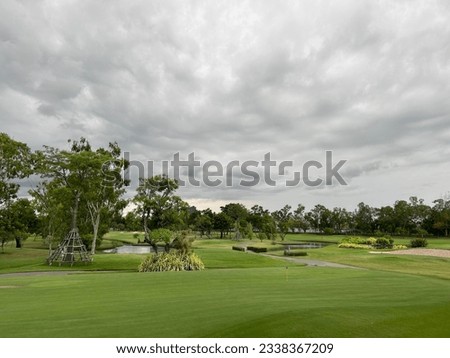 View of a golf course on a cloudy day in Bangkok, Thailand.