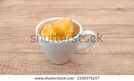 oranges in a cup on a wooden table