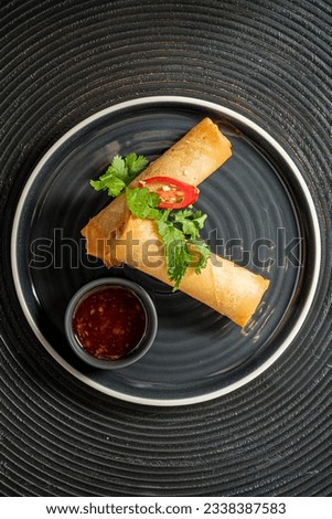 spring rolls on the black plate Royalty-Free Stock Photo #2338387583