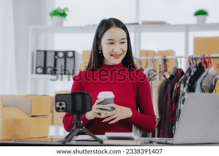 small business owner Young Asian woman wearing red shirt Working with laptop computer at office. Selling online. Ecommerce.