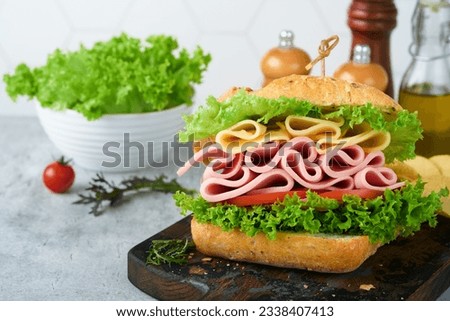 Sandwich. Tasty sandwich with ham or bacon, cheese, tomatoes, lettuce and grain bread. Delicious club sandwich or school lunch, breakfast or snack.