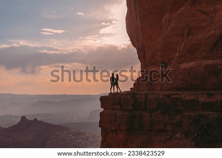 Silhouette of woman and man on the trail at Cathedral Rock at sunset in Sedona. The colourful sunset over Sedona's Cathedral Rock landmark Arizona