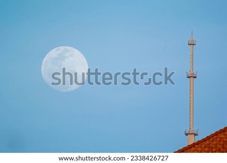 Evening moon with a blue sky. building in the background