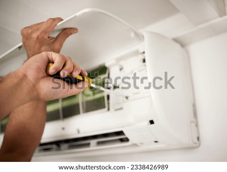 Maintenance, air conditioner and hands of man with screwdriver working on ventilation filter for ac repair. Contractor service, handyman or electric aircon machine expert problem solving with tools. Royalty-Free Stock Photo #2338426989