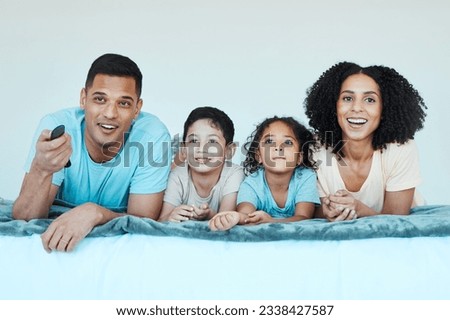 Father, mother and children on bed, watching tv and smile for comedy, comic movie and cartoon in family home. Happy parents, kids and television show with streaming, subscription and relax together