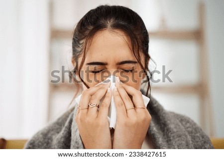 Tissue, nose and sick woman sneezing in living room with allergy, cold or flu in her home. Hay fever, sinusitis and female with viral infection, risk or health crisis in lounge with congestion Royalty-Free Stock Photo #2338427615