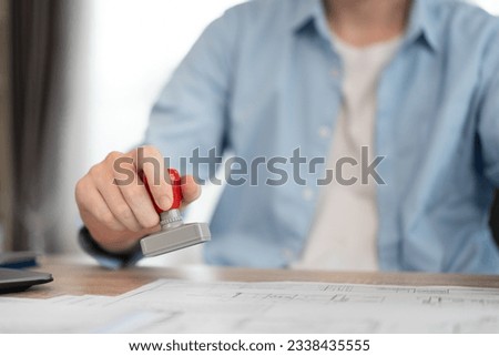 Unknown businessman working with rubber stamp and document at office	