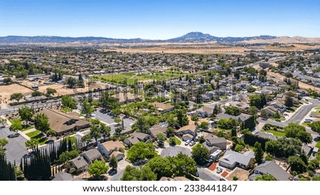 Aerial Photo over a neighborhood in Oakley, California with streets, trees, houses and a beautiful blue sky