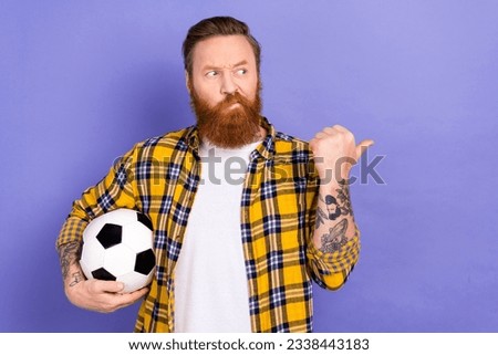 Photo of minded football fan wear plaid trendy clothes thumb presenting empty space suspicious offer isolated on purple color background Royalty-Free Stock Photo #2338443183