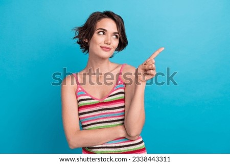 Photo of dreamy shiny woman dressed striped tank top showing finger empty space isolated blue color background