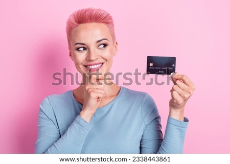 Photo of charming minded tricky girl wear blue stylish clothes hand demonstrate card emoney savings isolated on pink color background