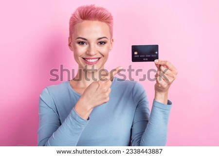 Photo of cheerful adorable rich lady wear blue stylish clothes arm demonstrating offer bank card isolated on pink color background
