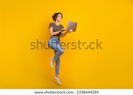 Full length photo of funky pretty girl dressed khaki top jumping writing modern gadget empty space isolated yellow color background