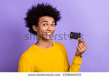 Photo portrait of young promoter advertiser man hold debit plastic card payment online with no taxes isolated on purple color background