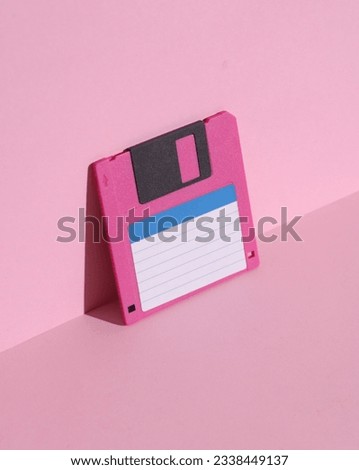 Floppy disk on pink background with shadow. Minimalism. Retro 80s creative layout Royalty-Free Stock Photo #2338449137