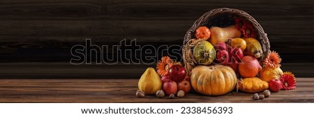 Thanksgiving day background with empty copy space. Pumpkin harvest in wicker basket. Squash, orange vegetable autumn fruit, apples, and nuts on a wooden table. Halloween decoration fall design. Royalty-Free Stock Photo #2338456393