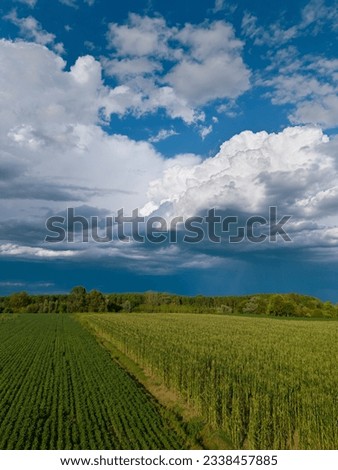 Aerial shot after the storm of a prairie with hay bales and deserted fields. Clouds without rain, sun and greenery.