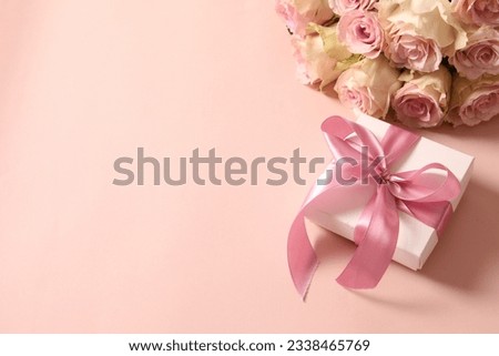 beautiful bouquet of flowers with a gift on a colored background