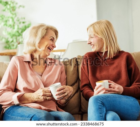 Portrait of happy mother and daughter or grandmother and granddaughter having fun  and having conversation at home